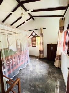 a living room with a ceiling fan and curtains at Villa Kethmin in Talpe