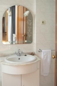 a bathroom with a white sink and a mirror at Cantinho da Celeste in Paramos