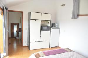 una camera da letto con un mobile bianco con un forno a microonde di Cantinho da Celeste a Paramos