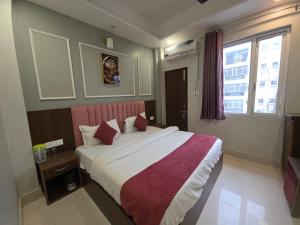 a bedroom with a large bed and a window at Hotel Shri Ji Palace in Haridwār