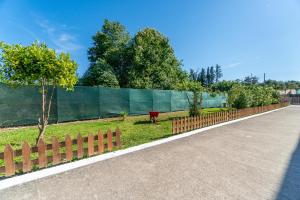 een hek met een rode koe die in het gras staat bij Saint Peter Bay Aparthotel in Kavos +33 foto's