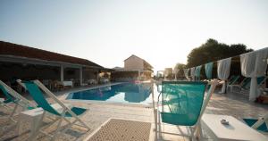 een zwembad met ligstoelen en een zwembad bij Saint Peter Bay Aparthotel in Kavos
