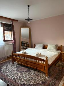 een slaapkamer met een groot houten bed en een spiegel bij Apartman 23 in Kraljevo +13 foto's