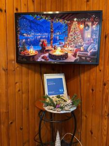 een televisie aan de muur met een laptop op een krukje bij Apartman 23 in Kraljevo