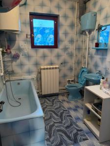 een badkamer met een bad, een toilet en een wastafel bij Apartman 23 in Kraljevo