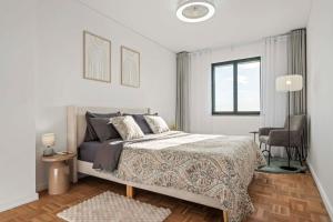 een witte slaapkamer met een bed en een stoel bij View in Bicas