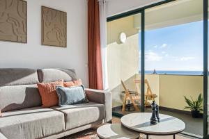 een woonkamer met een bank en uitzicht op de oceaan bij View in Bicas