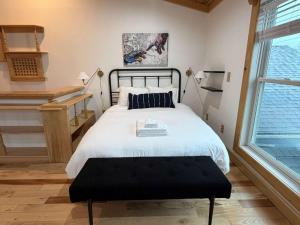 een slaapkamer met een bed en een groot raam bij Lake Rd E- Geneva in Saybrook-on-the-lake