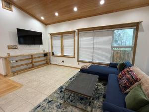 een woonkamer met een blauwe bank en een tv bij Lake Rd E- Geneva in Saybrook-on-the-lake