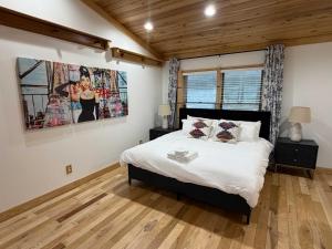 een slaapkamer met een bed en een schilderij aan de muur bij Lake Rd E- Geneva in Saybrook-on-the-lake