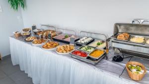 een buffet tafel met veel verschillende soorten eten op het bij Saint Peter Bay Aparthotel in Kavos