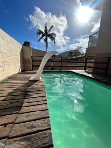 a swimming pool with a slide and a palm tree at Casa Silva enseada in Guarujá +7 photos