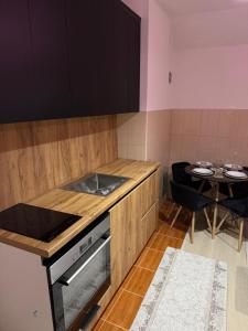 eine kleine Küche mit einem Herd und einem Tisch in der Unterkunft Apartment Mountain Paradise Plav in Plav