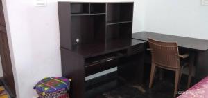 een zwart bureau met een stoel in een kamer bij Peacock Abode Farm in Bangalore +23 foto's