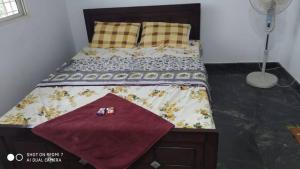 a bed with a comforter and pillows in a bedroom at Peacock Abode Farm in Bangalore