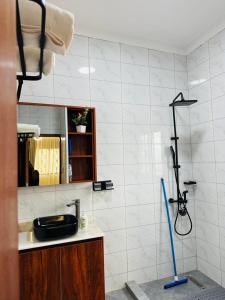 a bathroom with a sink and a shower at Sunset Statehouse View Residence B in Entebbe +33 photos