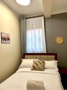 a bedroom with a large bed with a window at Sunset Statehouse View Residence B in Entebbe