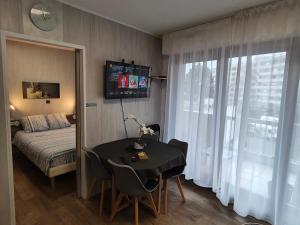 ein Schlafzimmer mit einem Tisch und einem Bett und einem Fenster in der Unterkunft Nart & Niar in Annemasse