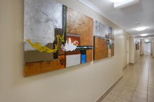 a hallway with four paintings on a wall at Best Western Kimba Lodge in Maryborough