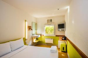 um pequeno quarto com uma cama e uma janela em ibis Budget Canberra em Camberra