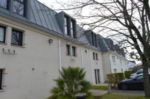 een gebouw met een auto ervoor geparkeerd bij Kyriad Argenteuil in Argenteuil