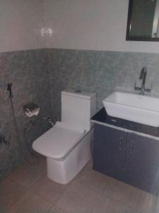 a bathroom with a toilet and a sink at Hill Side Heaven Homestay in Nainital