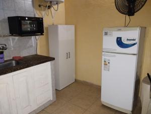 a kitchen with a white refrigerator and a microwave at CABAÑA NUESTRO HOGAR in San Rafael
