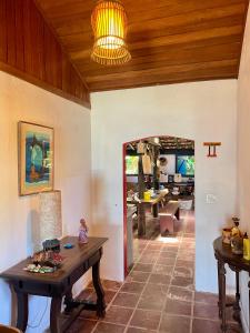 a living room with a wooden ceiling and a table at Janaína Picinguaba in Ubatuba