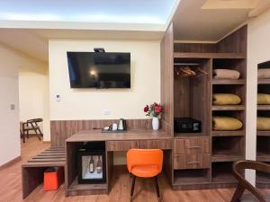 a desk with an orange chair in a room at SM HOTEL Plus in Lima