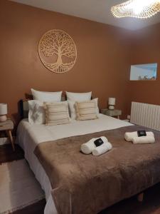 een slaapkamer met een groot bed met handdoeken erop bij Le Bis in Guer