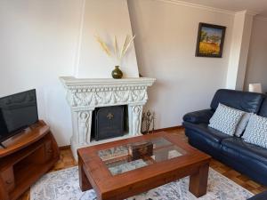 een woonkamer met open haard en een bank bij A CALZADA in Cambados