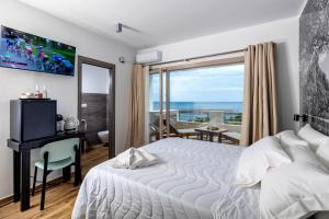 a bedroom with a bed and a desk and a window at Blue Bay rooms in Cala Gonone