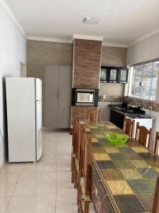 een keuken met een koelkast en een tafel met stoelen bij Casa Toledo in Olímpia