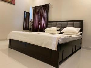 a bed with white pillows on it in a bedroom at LBS Farms in Coimbatore