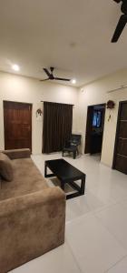 a living room with a couch and a table at LBS Farms in Coimbatore