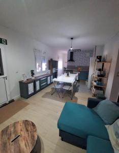 ein Wohnzimmer mit einem blauen Sofa und einem Tisch in der Unterkunft Casa cruce de los molinos in La Aldehuela + 28 Fotos