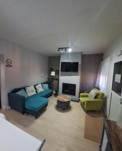 ein Wohnzimmer mit Sofa, Sesseln und Fernseher in der Unterkunft Casa cruce de los molinos in La Aldehuela