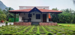 a small house with a red roof in a yard at LBS Farms in Coimbatore