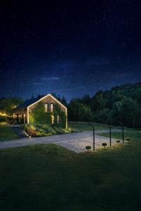 a house with lights on the side of it at night at Rezydencja Bieszczady - Solina in Solina