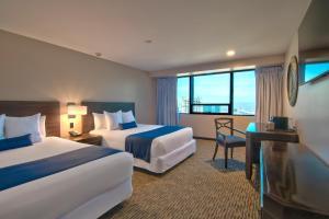 a hotel room with two beds and a desk at Grand Hotel Tijuana in Tijuana +52 photos