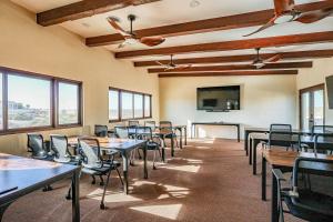 una sala conferenze con tavoli, sedie e TV a schermo piatto di Paz del Mar 16 guest a Las Conchas