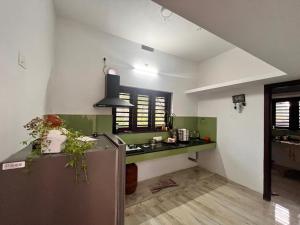 a kitchen with a counter and a refrigerator in a room at CloudNine Stay in Sultan Bathery +6 photos