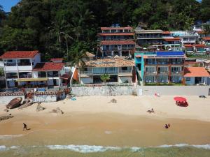 a group of people on a beach with buildings at Casa Varandão, 1ª praia, Morro de São Paulo in Cairu