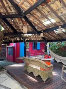 eine Terrasse mit Stühlen und einem Tisch und einem Holzdach in der Unterkunft Janaína Picinguaba in Ubatuba