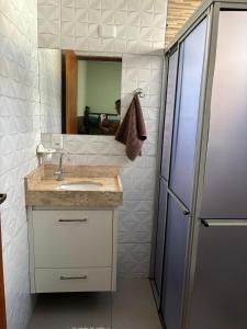 een badkamer met een wastafel, een spiegel en een koelkast bij Casa Toledo in Olímpia