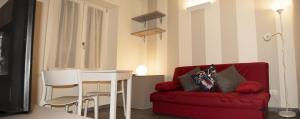 a living room with a red couch and a table at Albergo Covili in Pavullo nel Frignano