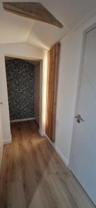 een lege kamer met een hal met een houten vloer bij Gîte de Dedette in La Grise