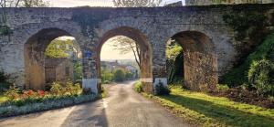 an old stone bridge with three arches on a road at Gîte de Dedette in La Grise
