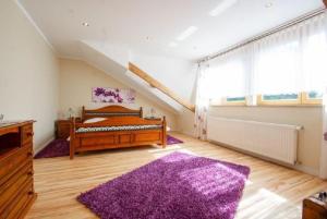 a bedroom with a bed and a purple rug at Landhaus Nadine in Kolonie Roeske