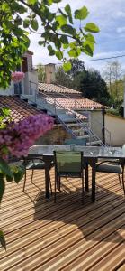 a table and two chairs on a wooden deck at Gîte de Dedette in La Grise +4 photos